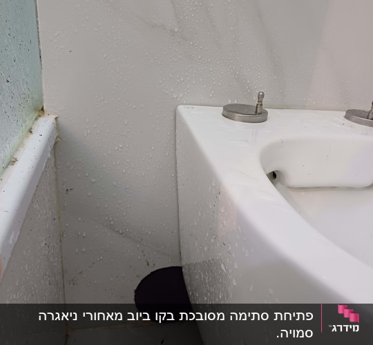 כיור עם חור בקיר לידו